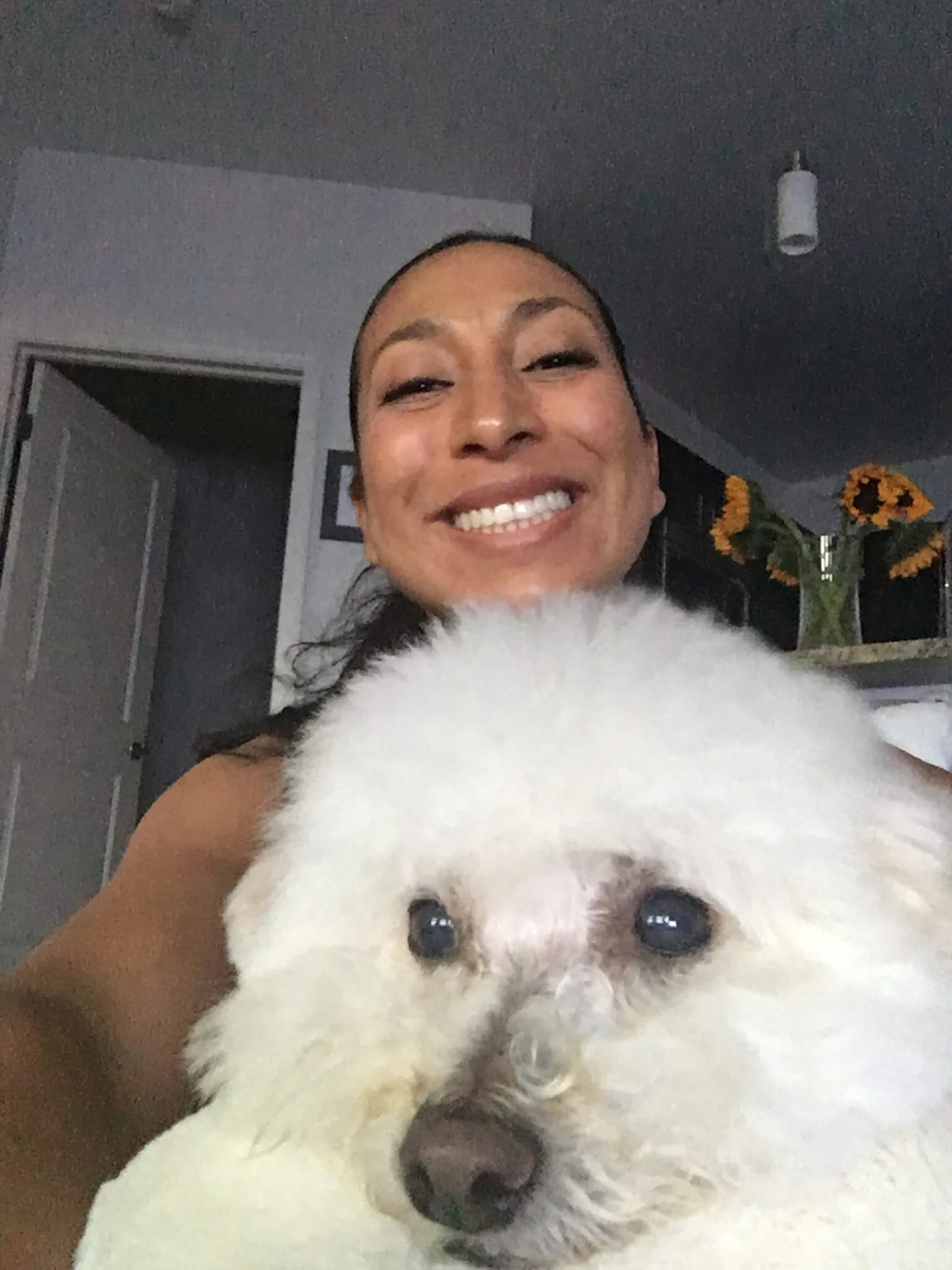 woman smiling and taking a selfie with her dog