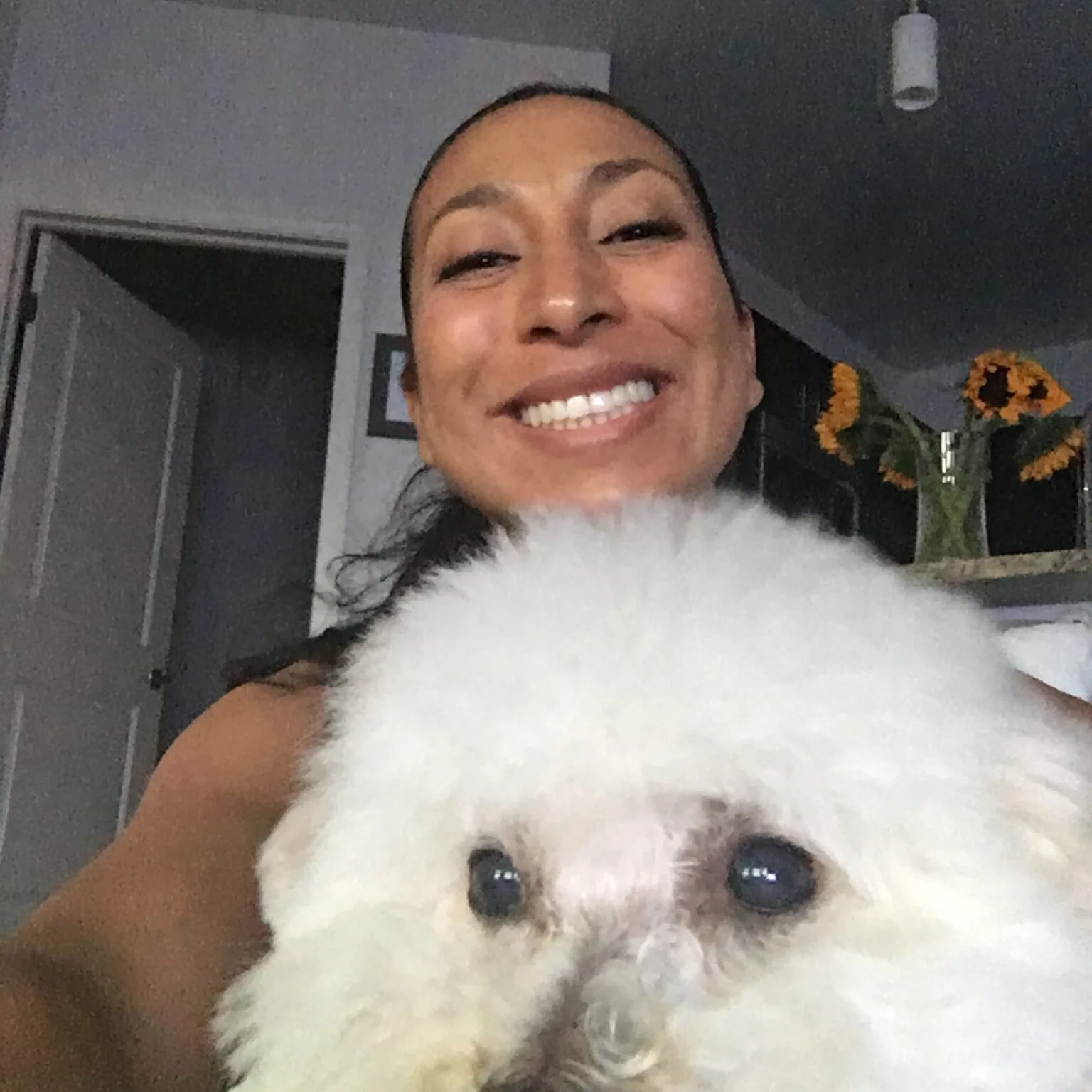 woman smiling and taking a selfie with her dog